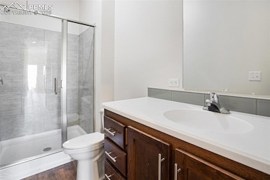 Full bathroom with toilet, a shower stall, and van