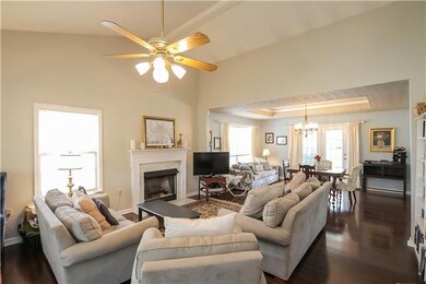 Fantastic great room with soaring ceiling, gleaming floors, fireplace and natural light galore.