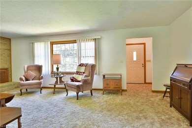 Living area featuring brick wall and light carpet