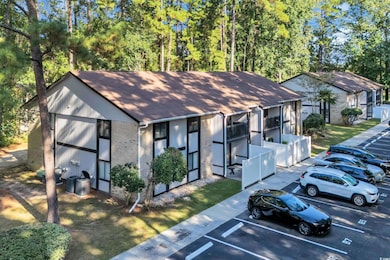 View of front of home featuring brick siding, uncovered parking, and a shingled roof