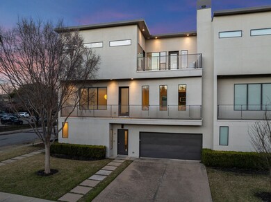 Contemporary house featuring a balcony, stucco siding, driveway, and an attached garage