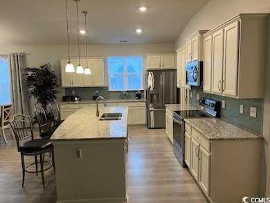 Kitchen featuring sink, an island with sink, penda