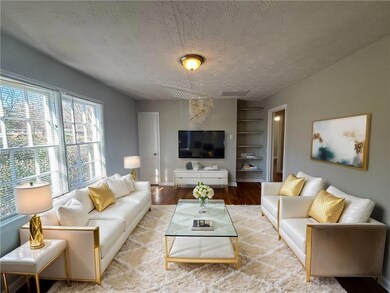 Living area with built in features, visible vents, light wood-style floors, a textured ceiling, and baseboards