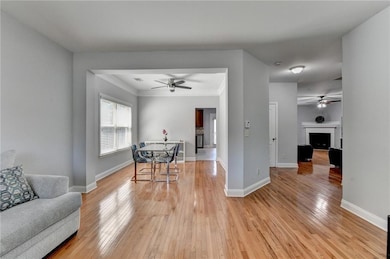 Dining area featuring light wood-style floors, ceiling fan, crown molding, and baseboards