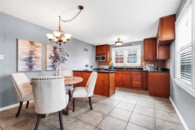 Kitchen with decorative backsplash, hanging light fixtures, a healthy amount of sunlight, and an inviting chandelier