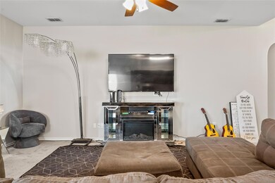 Carpeted living room featuring visible vents, a gl