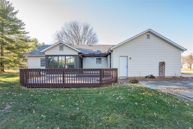 Two-tiered back deck with a pergola. Concrete patio to the left of the garage