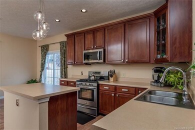 Kitchen has laminate wood flooring and stainless s