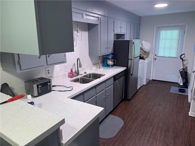 Kitchen featuring dishwasher, a sink, dark wood-st