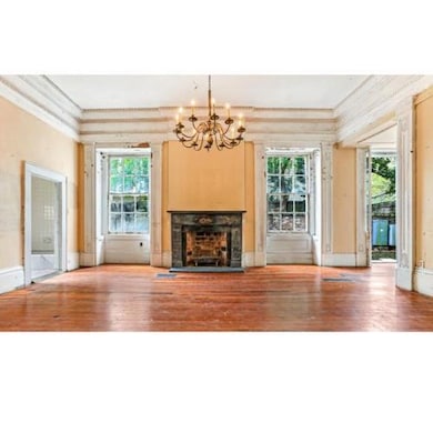 First floor unit living room. Original hardwood floors and original Egyptian Marble mantles. Much of the original millwork and plaster adorn this unit which has both front and rear entry as well as a private courtyard entrance to a parking space.