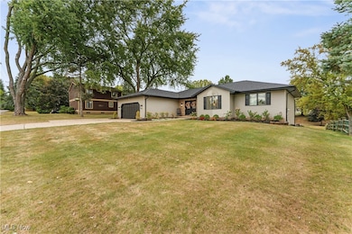 View of front of property featuring a front lawn, an attached garage, and driveway