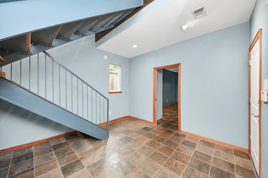 Welcoming foyer with elegant tile flooring and open staircase, setting the tone for the home's inviting atmosphere.