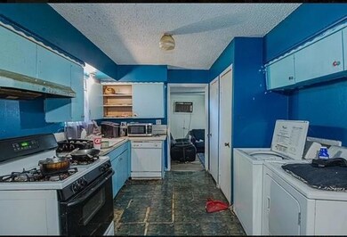 Kitchen featuring dark tile floors, white applianc