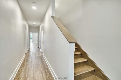 Stairs with wood finished floors and recessed ligh