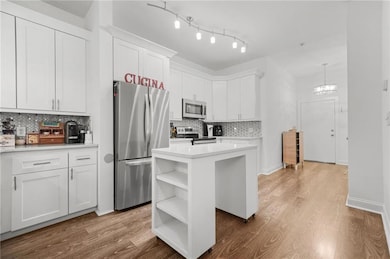 Kitchen featuring white cabinetry, stainless steel