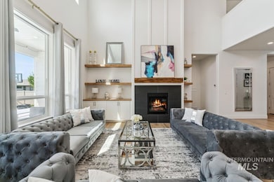 Living area with a high ceiling, a fireplace, light wood-style flooring, and recessed lighting