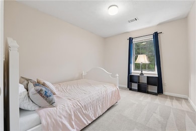 Carpeted bedroom with visible vents and baseboards