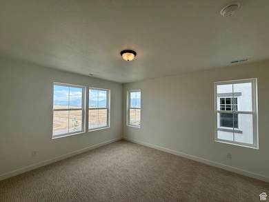 Spare room featuring light carpet and a smoke detector