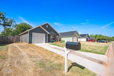 View of front of house featuring a garage and a front yard