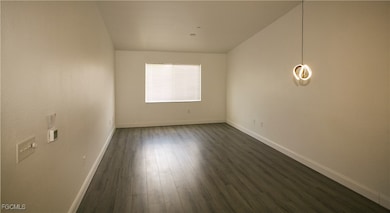 Unfurnished room featuring dark wood-style floorin