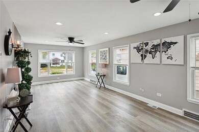 Sitting room featuring ceiling fan and light hardw