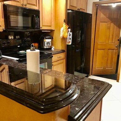 View of kitchen, granite counters, black appliance