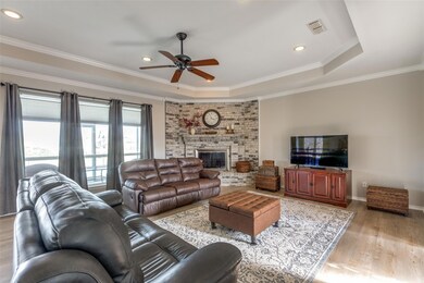 Living room with crown molding, ceiling fan, light