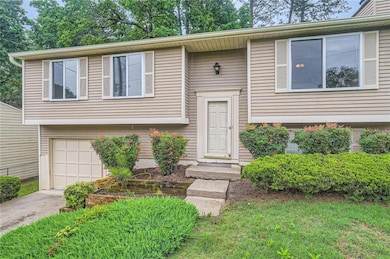 Split foyer home featuring a garage and concrete driveway