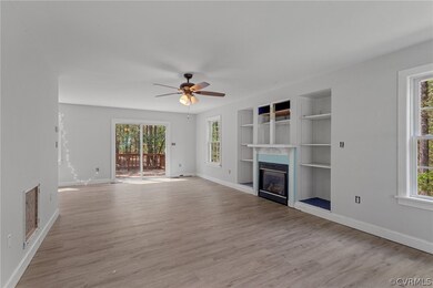 Unfurnished living room featuring ceiling fan, light hardwood / wood-style flooring, built in features, and plenty of natural light