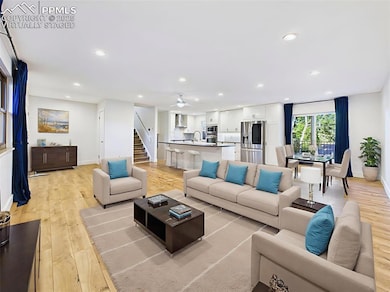virtually staged view highlights the generous scale of the space, easily fitting a dining area, lounge, and bar seating at the kitchen island.