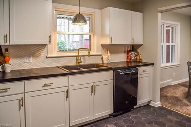The kitchen has black stained butcher block counte