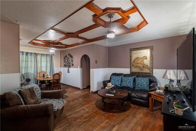Living room with ceiling fan, a textured ceiling, coffered ceiling, and hardwood / wood-style flooring