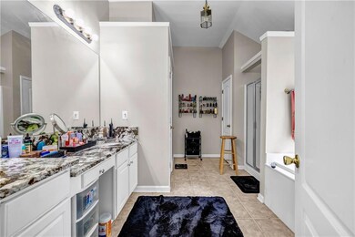 Bathroom featuring vanity, tile patterned flooring, a stall shower, and baseboards