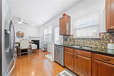 Kitchen featuring a sink, a ceiling fan, dark ston