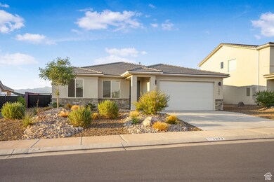 View of front of house featuring stone siding, stucco siding, driveway, and a garage