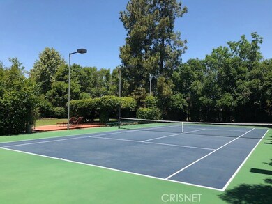 Full regulation, lighted north/south tennis court w/seating & viewing area/pergola to the side