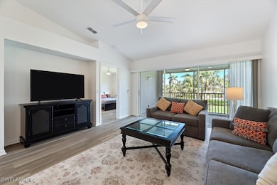 Living area with wood finished floors, vaulted ceiling, and ceiling fan