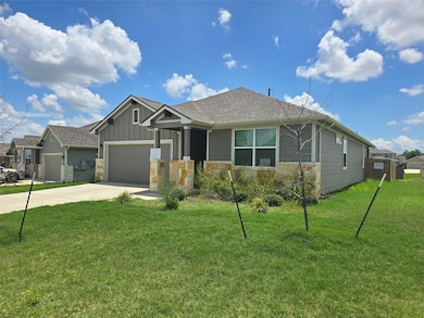 Craftsman-style home featuring driveway, stone si
