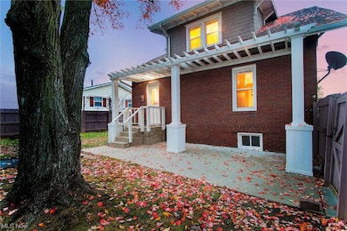 Back house at dusk with a pergola and a patio