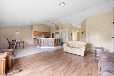 Tiled living room featuring high vaulted ceiling
