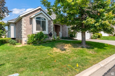 View of front of house featuring brick siding, a garage, a front and side lawn, driveway