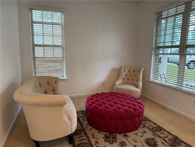 Sitting room featuring healthy amount of natural light, carpet flooring, and baseboards