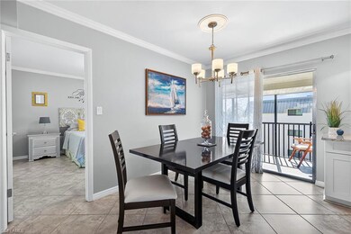 Dining room with ornamental molding, a chandelier, and light tile patterned floors