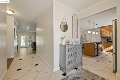 Hallway featuring ornamental molding, light tile patterned flooring, and french doors