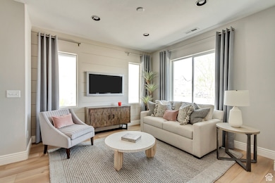 PHOTOS FOM SIMILAR MODEL HOME. FINISHES, COLORS, AND OPTIONS WILL VARY. Living area featuring light wood finished floors and recessed lighting