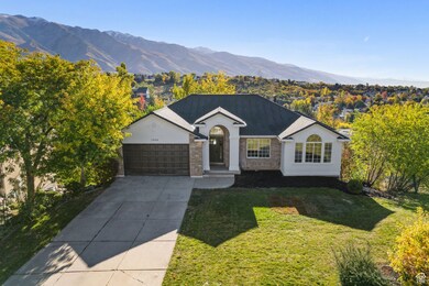Single story home with a mountain view, concrete driveway, a front yard, a garage, and stucco siding
