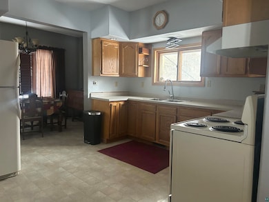 Kitchen featuring a notable chandelier, white appl