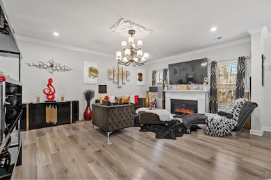 Living room featuring ornamental molding, a chande