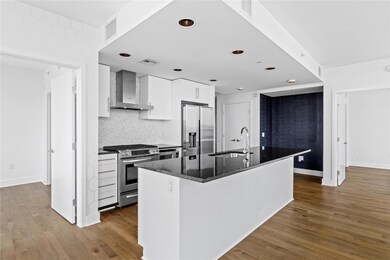 Kitchen featuring wall chimney exhaust hood, appl
