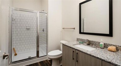 Kitchen featuring stainless steel refrigerator, ceiling fan, tasteful backsplash, sink, and pendant lighting